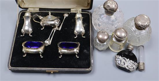 A 1920s cased five piece silver condiment set, five silver mounted scent/toilet bottles and one other scent bottle.